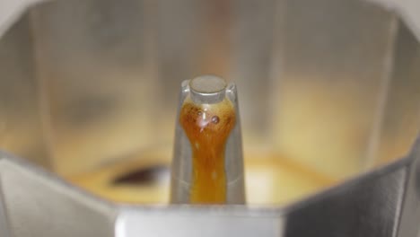 slow-motion capture of coffee emerging from a moka pot