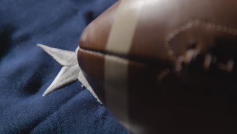 focus pulls from close up shot of american football to stars and stripes flag 1