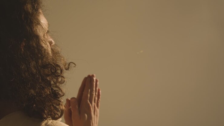 Portrait Of Man With Long Hair And Beard Representing Figure Of Jesus Christ Putting Hands Together In Prayer