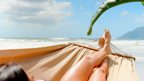 young caucasian woman sleeping in hammock at beach 4k