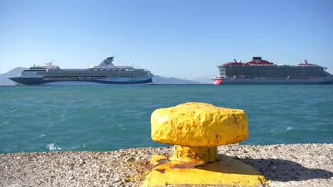 yellow bollard at the port by the shores of the ionian sea, with cruise ships in the background