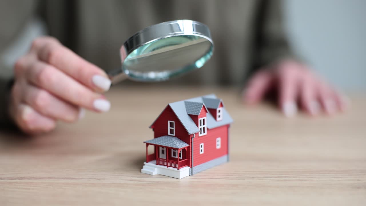Examining a Miniature House with a Magnifying Glass