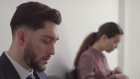 candidatos masculinos y femeninos en el cargo esperando una entrevista de trabajo mirando el teléfono móvil y leyendo notas 6