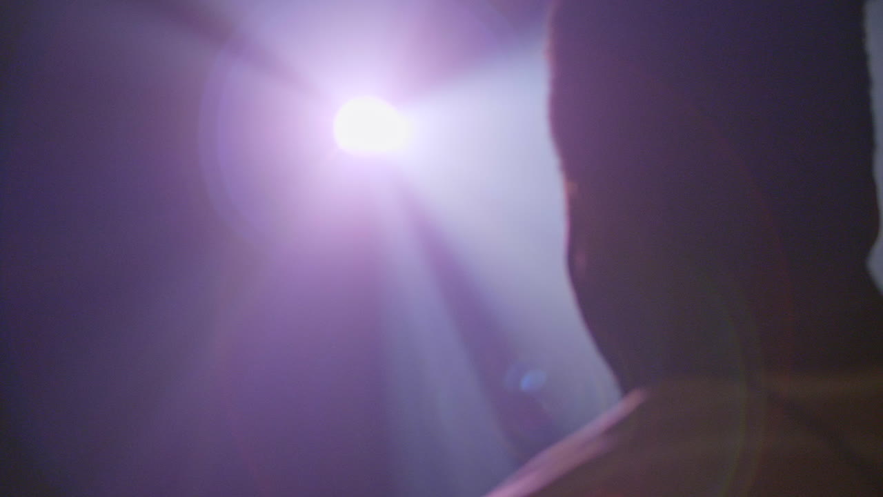 영사기의 빛에 닿는 아프리카계 미국인 남자