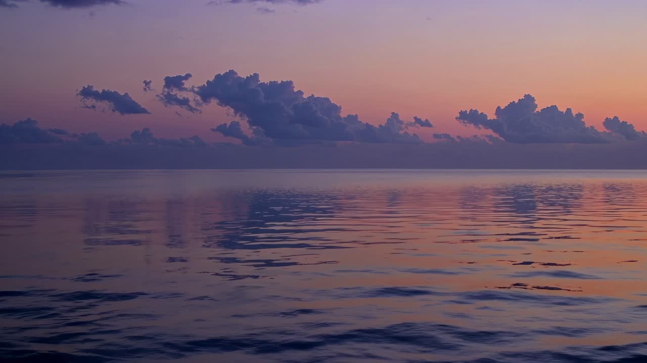 A serene sunset over calm waters, captured in a wide-angle shot