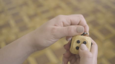 manos de mujer jugando con un juguete de cubo fidget