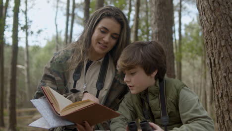 Caucasian-mother-and-her-curious-son-birdwatching-in-a-natural-park-on-autumn-day