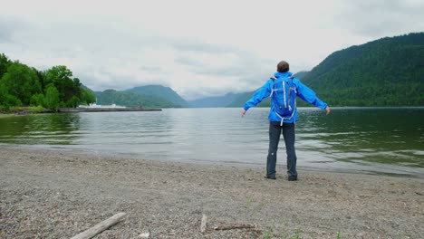 man enjoying the view of a mountain lake