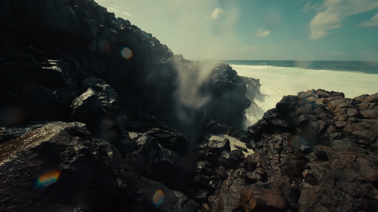 강력한 파도가 화산암에 부히고