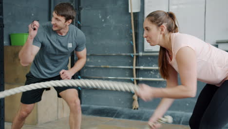 couple working out with exercise rope in gym