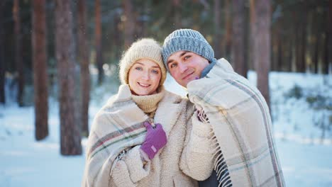 Couple enjoying winter day in a snowy forest