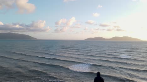 man standing on top of cliff looking towards ocean and islands, vlore, albania