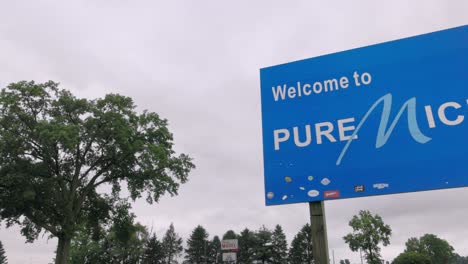 para dar la bienvenida a puro signo de michigan en la línea estatal de michigan e indiana con panorámica de video de izquierda a derecha