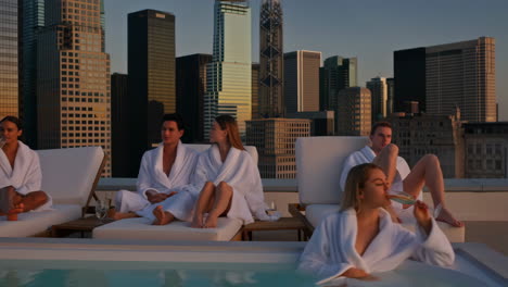 people relaxing by rooftop pool with city view