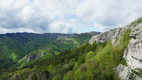 aerial forward over green rhodope mountains overgrown with green plants during cloudy day, bulgaria