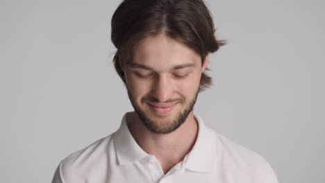 caucasian confident man in front of camera on gray background.