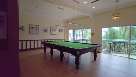 una mesa de billar vacía en una habitación al lado de las ventanas en un hotel en las tierras altas de cameron, malasia.