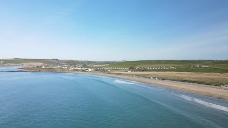 Eine-Luftaufnahme,-Die-An-Einem-Sonnigen-Tag-In-Irland-Einem-Langen-Sandstrand-Mit-Sanften-Wellen-Folgt