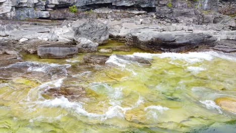 Sich-Zurückziehende-Drohnenaufnahme-Des-Abwechselnden-Vordringens-Und-Zurückziehens-Von-Wasser-Entlang-Der-Zerklüfteten-Küste-Der-Georgian-Bay-In-Ontario,-Kanada