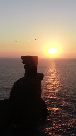 stunning sunset over ocean with dramatic rock formation