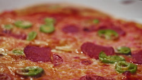 Close-up-shot-of-a-fresh-hot-and-spicy-delivery-pizza-with-jalapenos-and-salami