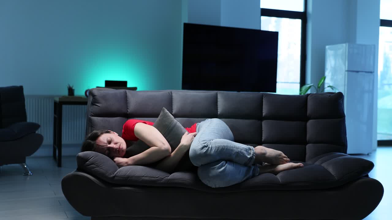 소파에서 위통을 겪는 여성