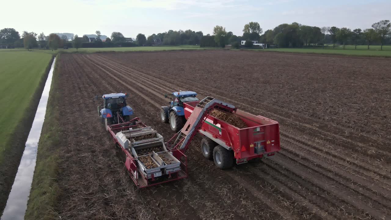 시골 땅 무인 항공기 높은 각도에 트랙터와 감자 작물을 수확하는 농부