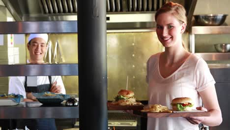 woman holding burger and french fries at restaurant