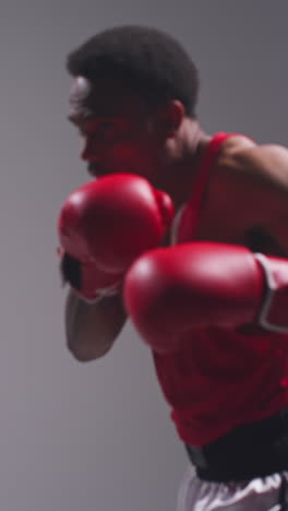 vertical video close up shot of male boxer wearing gloves in boxing match throwing punches at opponent