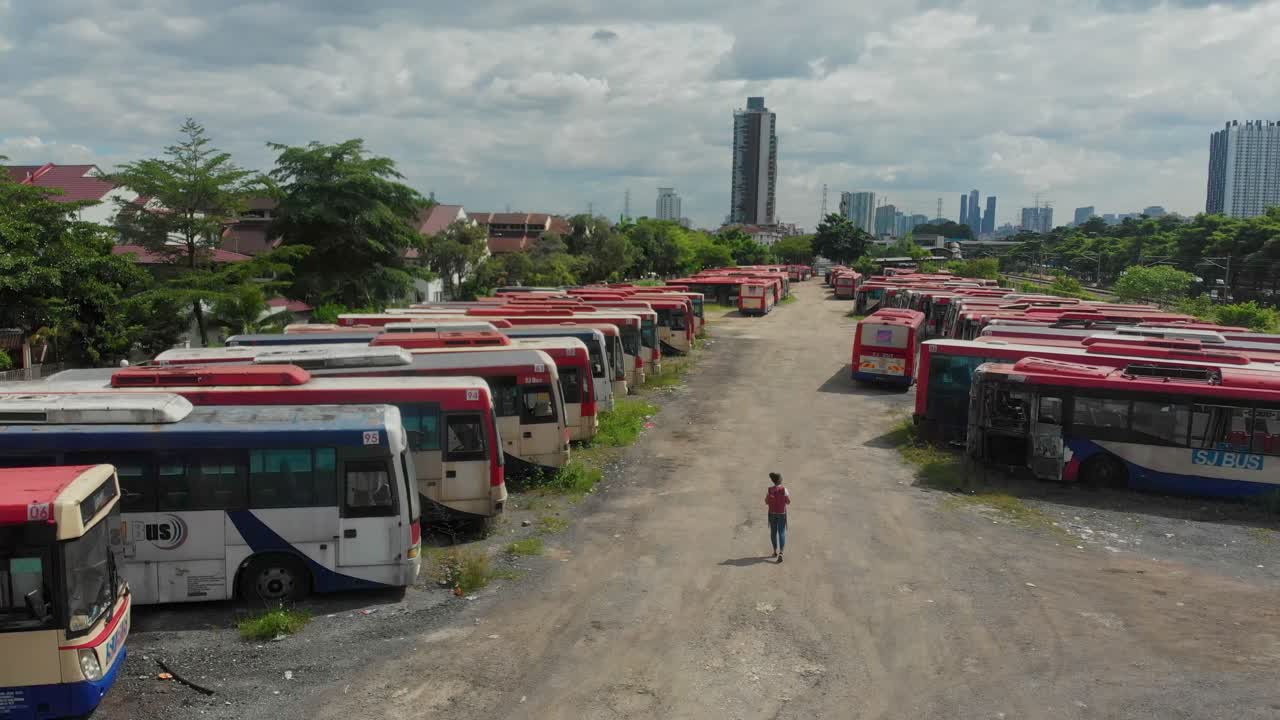 Aerial view of vehicle graveyard filled with abandoned old buses in Kuala Lumpur Malaysia