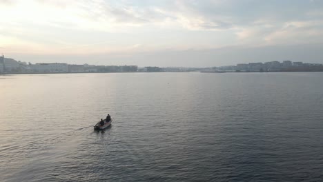 two fishermen sitting in their boating on their way to karlskrona, sweden on a beautiful cloudy day close to sunset