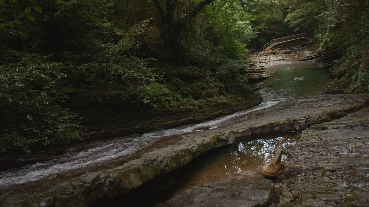 serena cascada de montaña y escena del río con la gente