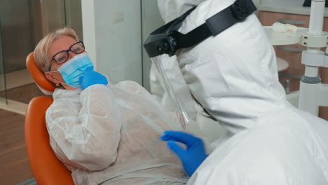 doctor with coverall listening patient dental problem