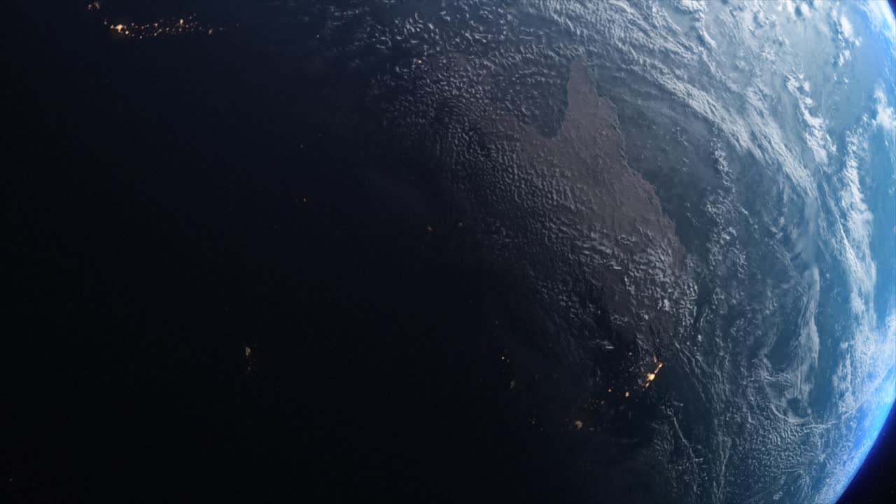 Stunning CGI mid-shot of the planet Earth from space with dawn spreading across the Australian continent, with the distinct lights from habitation glittering in the night time zones