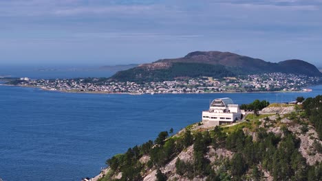 alesund municipality and islands, norway, aerial view of viewpoint building above fjord and city, drone shot 60fps