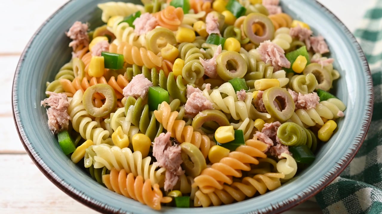 Pasta salad with tuna, corn and olives in bowl