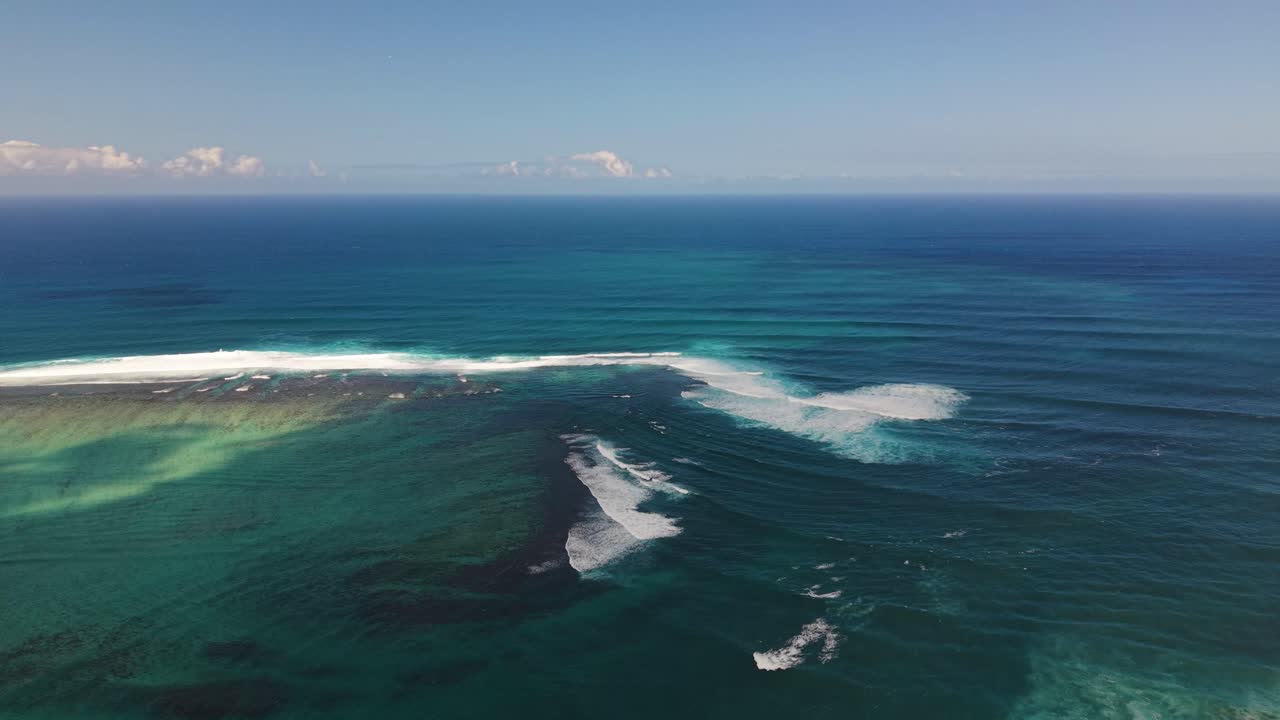 Odkrytý záběr z dronu nad Indickým oceánem poblíž Mauricia, který ukazuje vlnící se vlny a hlubokou vodu, jež vytvářejí výraznou optickou iluzi podvodního vodopádu. Dynamická příroda