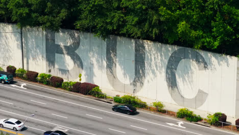 Cars-Driving-Through-Lenox-Road-Along-The-PATH400-And-Buckhead-Wall-In-Atlanta,-Georgia