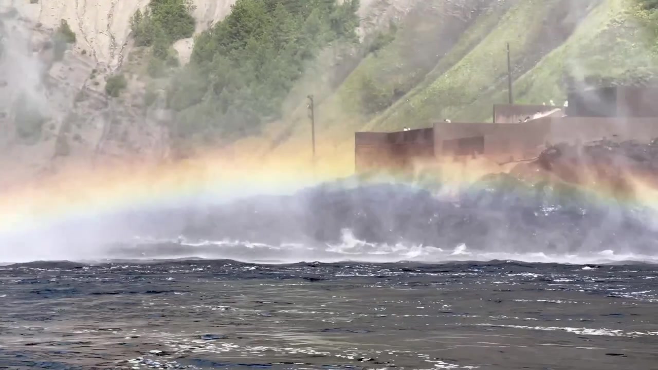 Horisontalt skud ved Montmorency-vandfaldene, der viser bunden af kaskaden, den opadgående trappe og en regnbue, der viser sig over den tågede vandoverflade