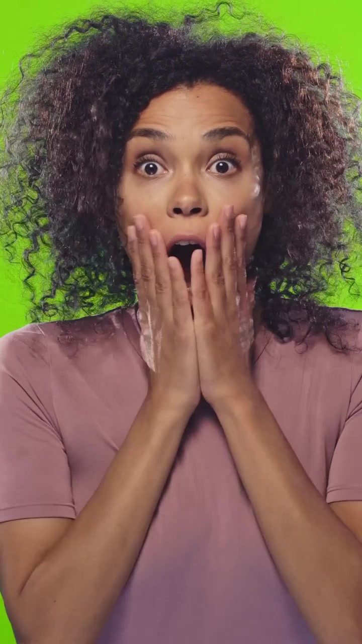 Donna afroamericana scioccata che sussulta e spalanca la bocca per la sorpresa su sfondo verde