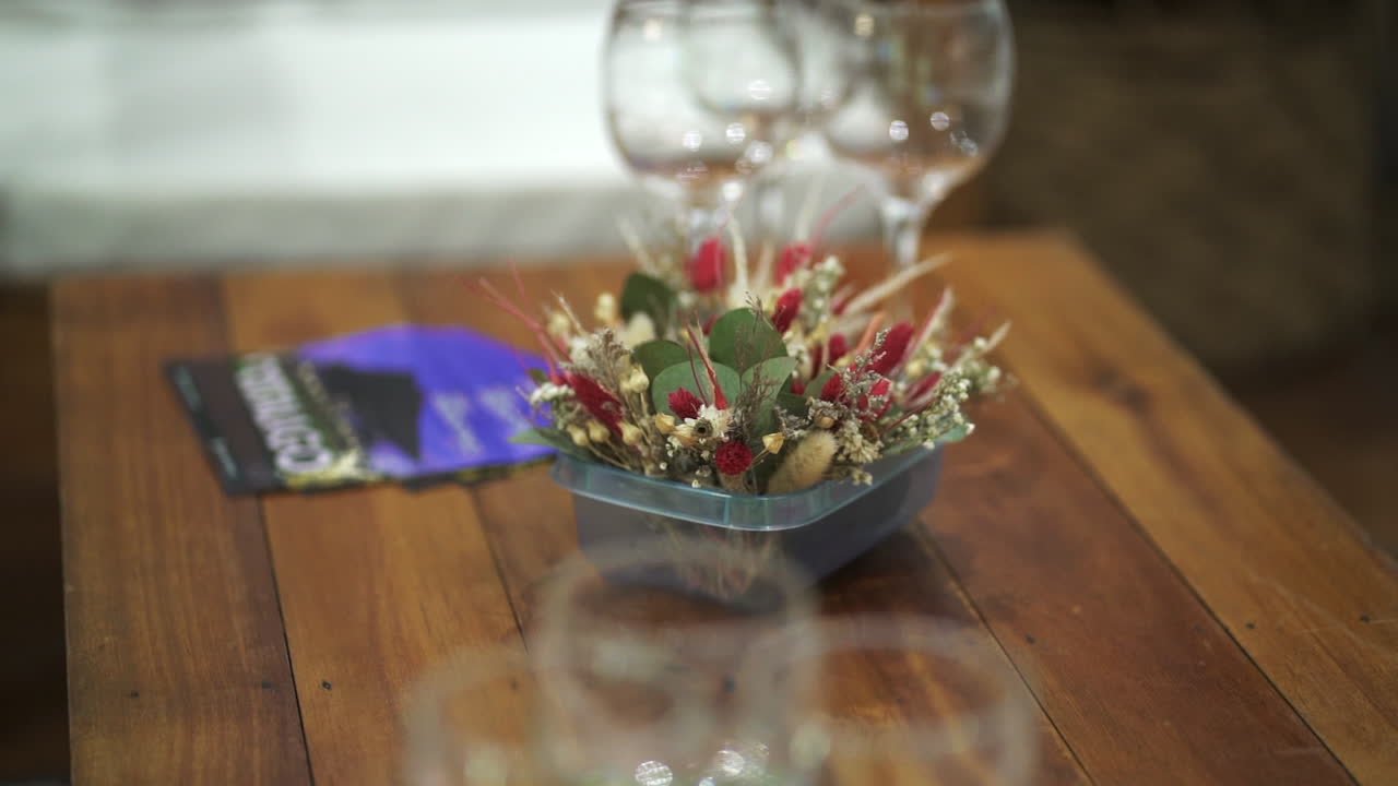 A decorative centerpiece featuring dried flowers in a cozy indoor setting