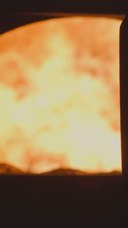 flame burning in large industrial furnace with open door at metalworking plant. powerful direct fired heater used at factory. dangerous equipment