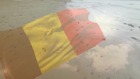 Digital-composition-of-waving-belgium-flag-against-aerial-view-of-the-beach