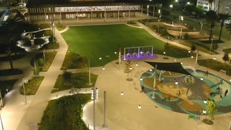 aerial fly by shot of lincoln park in downtown long beach | night time