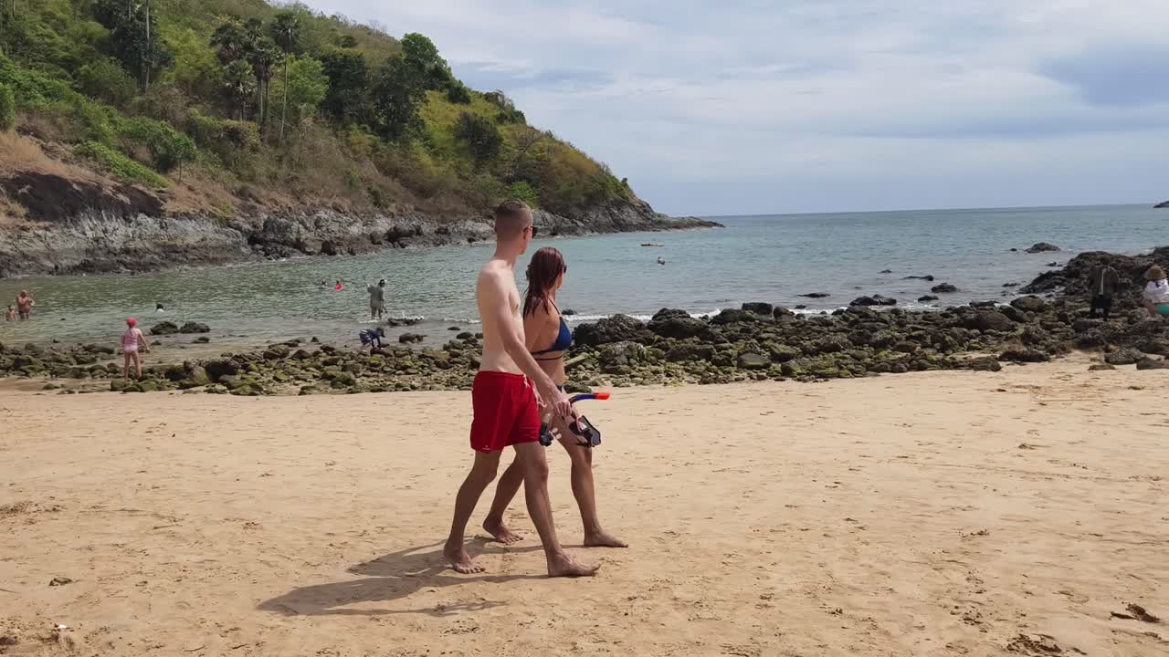 personas caminando por una playa tropical