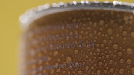 Close-Up-Of-Condensation-Droplets-On-Revolving-Takeaway-Can-Of-Cold-Beer-Or-Soft-Drink-Against-Yellow-Background