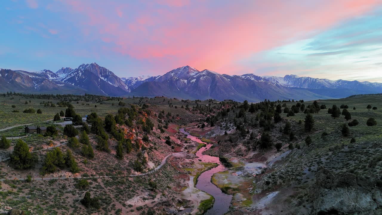 Aerial view ascending in front of a winding river, sundown in Hot Creek, CA, USA