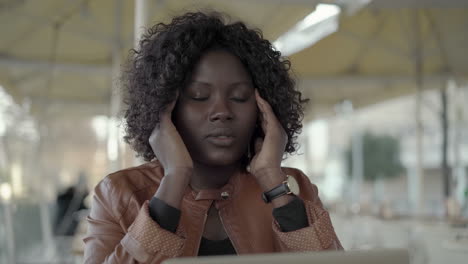 Overloaded-young-woman-working-with-laptop-in-cafe