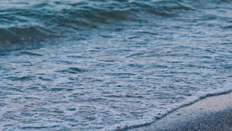 sea waves on the seashore. amazing view of the sea water. waves crash on the pebble beach making white foam. slow motion.