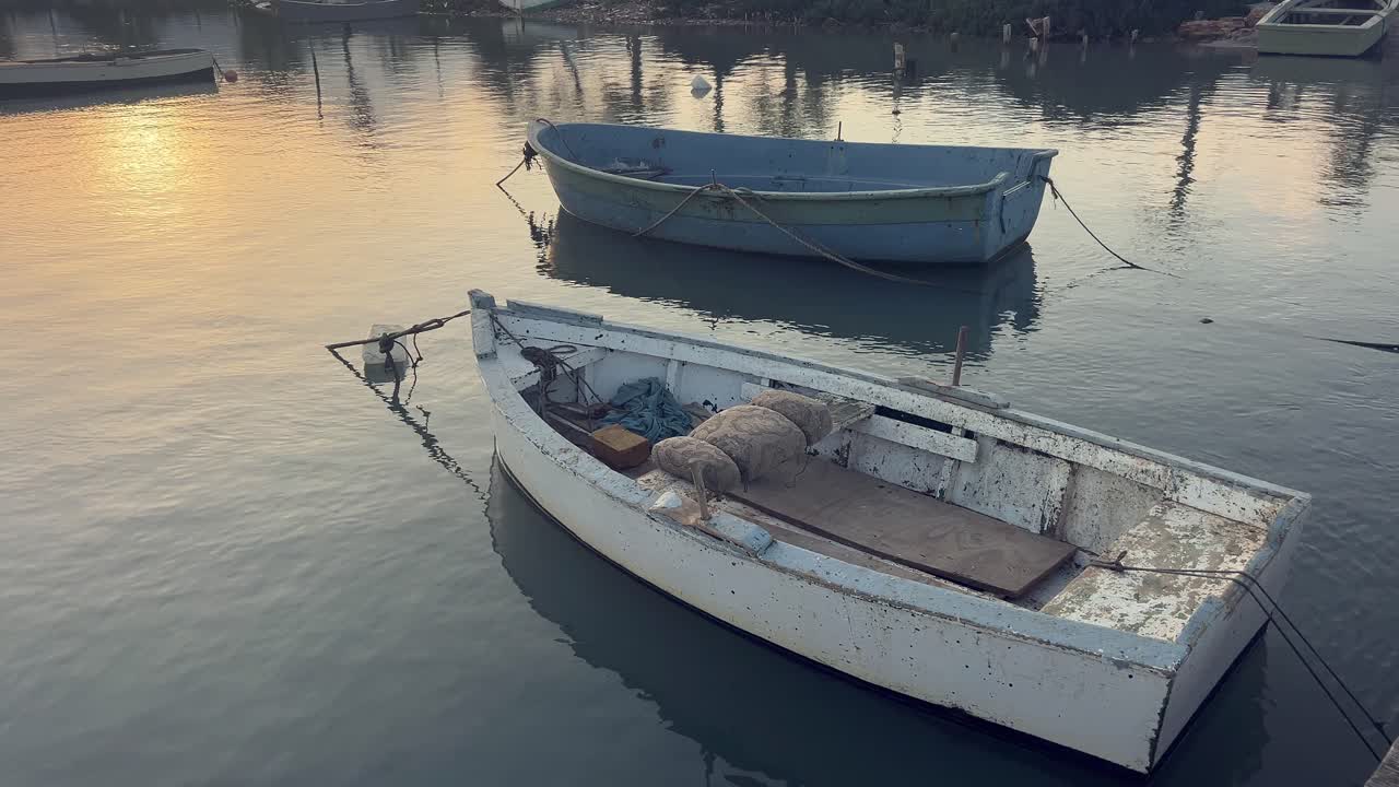 버려진 상태에서 정박한 두 배의 정적 시각. 해가 지는 빛